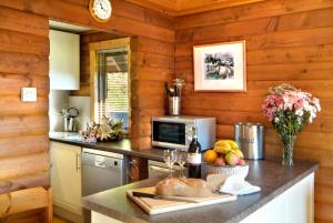 a kitchen with wooden walls and a counter with food on it at Thistle Lodges at Sandyhills Bay in Dalbeattie