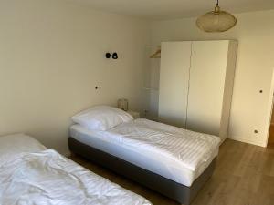 een slaapkamer met 2 bedden en een witte kast bij Monteurswohnung mit kleinem Garten 600M zur Stadtmitte in Siegen