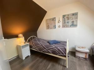 een kleine slaapkamer met een bed en een nachtkastje bij Tuusje in Vrouwenpolder