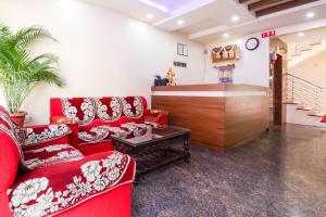 a living room with red couches and a clock at Champion Comfort Near Hosahalli Metro Station in Bangalore