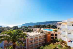 a view of a building and a palm tree at Ange Gardien IV AP4326 By Riviera Holiday Homes in Villefranche-sur-Mer