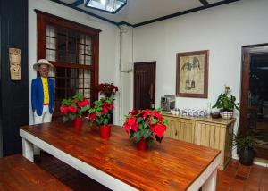 un hombre de pie en una habitación con flores en una mesa en Holland House B&B, en Durban