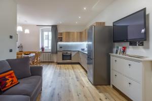a living room with a couch and a kitchen at DolomiApartments - Campanil 1 e 2 in Predazzo