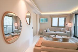 uma sala de estar com um sofá e um espelho em GRAY Renovated luxurious apartment located in Cannes em Cannes