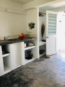 cocina con armarios blancos y encimera en Banana Bay Beach Club en Port Vila