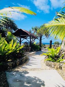 ポートビラにあるBanana Bay Beach Clubの椰子の木が生える浜辺へつづく遊歩道