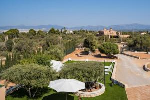 Villa Can Bellmunt في La Aranjasa: اطلالة على حديقة مع مظلة