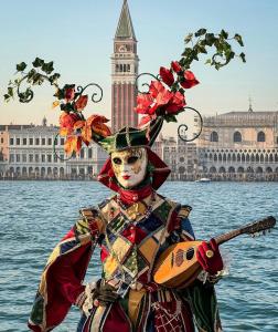 a person in a costume with a guitar in the water at Casa di Isabelle Venezia in Mestre