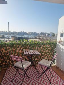 two chairs and a picnic table on a balcony at Sol y Luz in Isla del Moral