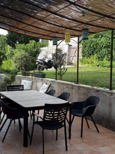 een tafel en stoelen onder een pergola op een patio bij Au Chat Perché espace familial in Mareil-sur-Mauldre