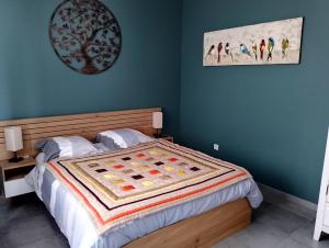 een slaapkamer met een bed met een deken erop bij Gîte & SPA Les Hirondelles de 2 à 8 personnes in Arnèke