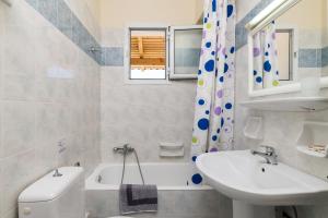 a bathroom with a sink and a toilet and a tub at Villa Georgia in Argassi +71 photos
