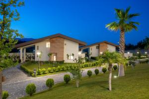 a house with a palm tree in front of it at BN Hotel Thermal & Wellness in Mersin