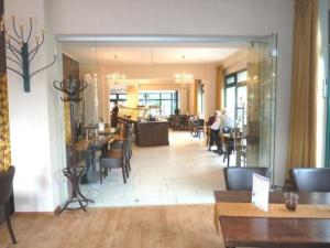 a lobby of a restaurant with people sitting at tables at Hotel Klusenhof in Lippstadt