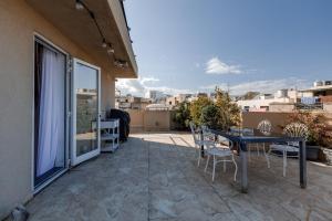 a patio with a table and chairs on a balcony at Talbot & Bons Studio Flat in Gudja