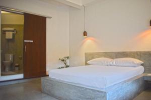 a bedroom with a bed and a bathroom with a toilet at City Beds Colombo in Colombo