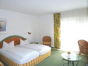 a hotel room with a bed and a table at Hotel Klusenhof in Lippstadt