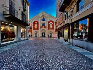 een geplaveide straat voor een groot gebouw bij Prestigioso attico a passo Duomo by Revenue House in Casale Monferrato