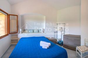 um quarto com uma cama azul com toalhas em 24PN - Vecchio Marino splendido villino vista mare em Palau