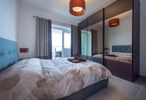 ein Schlafzimmer mit einem großen Bett und einem großen Spiegel in der Unterkunft Seafront Luxury Apartment with Pool in Sliema