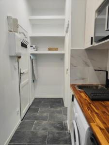 a kitchen with white cabinets and a tile floor at Charmant appartement hyper centre métro gare in Toulouse