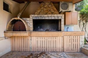 an outdoor pizza oven with a stone fireplace at Panos Apartment in Kefallonia