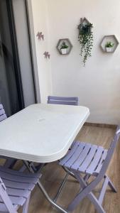 una mesa blanca y sillas en una habitación en Charmant studio lumineux Casablanca, en Bouskoura