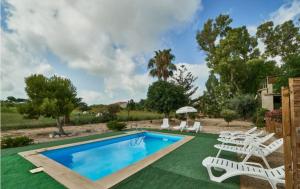 une piscine avec des chaises blanches et une pelouse avec une piscine dans l'établissement Casa Sorrapa con Piscina, à Deltebre
