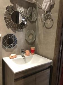 uma casa de banho com um lavatório branco e um espelho. em Charmant studio lumineux Casablanca em Bouskoura