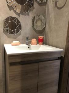 baño con lavabo blanco y espejos en Charmant studio lumineux Casablanca, en Bouskoura