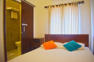 a bedroom with a bed with two colorful pillows on it at City Beds Colombo in Colombo