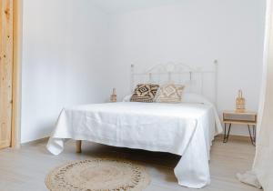 - une chambre avec un lit blanc et des oreillers dans l'établissement Finca de l’Anglés. Levante, à Potríes
