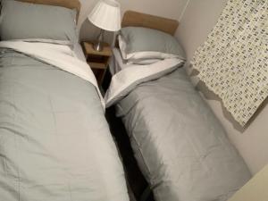 two beds sitting next to each other in a bedroom at Holiday home by the sea in Leysdown-on-Sea