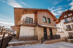 a house in the snow with a balcony at Villa (second floor) in CRYSTAL in Bakuriani