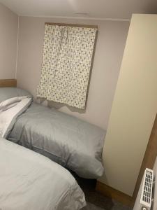 a small bedroom with a bed and a window at Holiday home by the sea in Leysdown-on-Sea