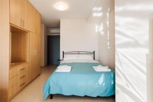 een slaapkamer met een bed met een blauw dekbed bij Georgia Seaview apartments A4 in Kalamata