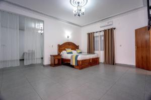 1 dormitorio con cama y lámpara de araña en Hôtel le Relais de Kolda, en Kolda