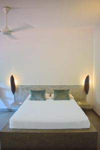 1 dormitorio con 1 cama grande con sábana blanca en City Beds Colombo, en Colombo
