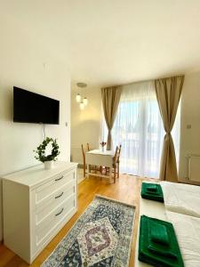 a bedroom with a bed and a table and a television at Libás Apartman in Keszthely