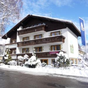 un edificio con nieve delante en Hotel Restaurant Amadeus, en Bad Hindelang