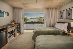 a bedroom with two beds and a large window at PACIFIC 19 Kona in Kailua-Kona