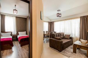Habitación de hotel con dormitorio y sala de estar. en Villa (second floor) in CRYSTAL en Bakuriani