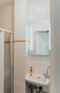 La salle de bains blanche est pourvue d'un lavabo et d'un miroir. dans l'établissement Haarlemmerstraat Central Studio, à Amsterdam
