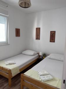 two twin beds in a room with a window at Apartment Tea in Rab