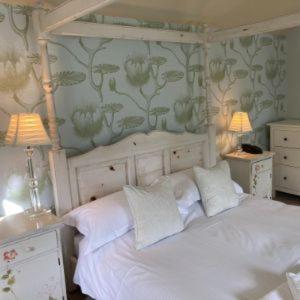 a bedroom with a white bed with two tables and two lamps at The Punch Bowl Inn in Feetham