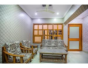 sala de estar con sillas, mesa y ventana en Hotel Rukmani Palace, Sri Ganganagar, en Gangānagar