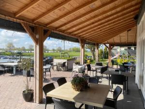 a patio with tables and chairs and a wooden pergola at Bell Tent in Heerewaarden