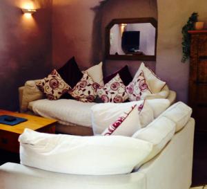 a couch with pillows on it in a living room at Tyddyn Bach Barn in Betws-y-coed
