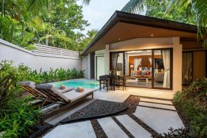 a villa with a swimming pool and a house at Dewa Phuket Resort & Villas in Nai Yang Beach