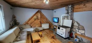 Biocinovici vikendica في كولاسين: غرفة معيشة مع أريكة وتلفزيون